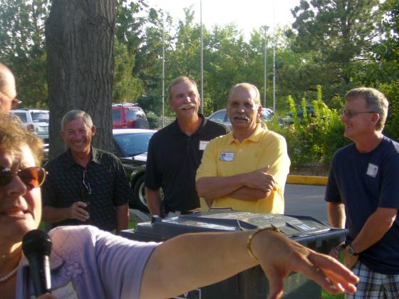 Marlene gives the group instructions, while Lenny, George, Dennis, and Bob think it's like trying to herd Cats.